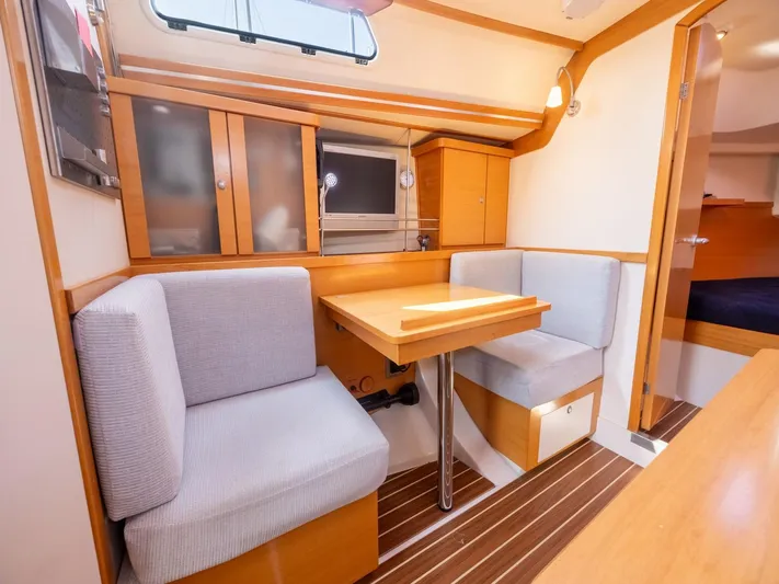  Yacht Photos Pics Cozy interior of 2006 Hanse 370 yacht with dining area and wooden cabinetry.