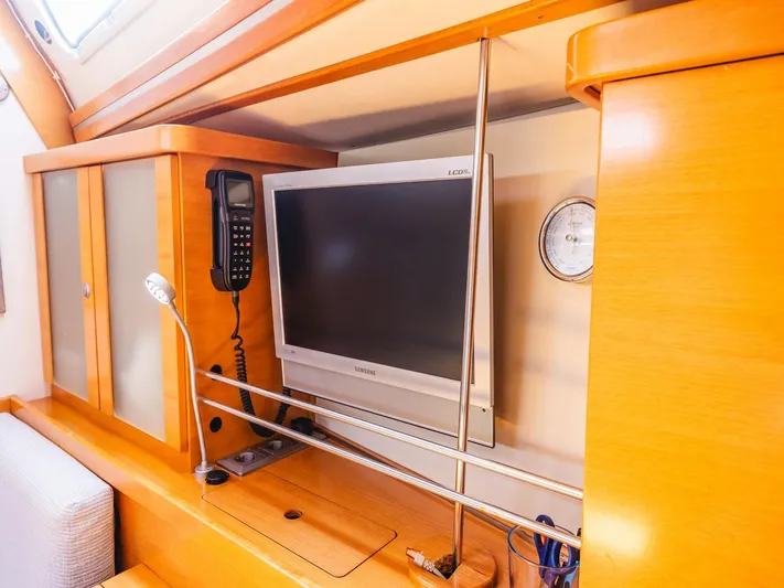  Yacht Photos Pics Interior of 2006 Hanse 370 yacht with TV, phone, and wooden cabinetry.