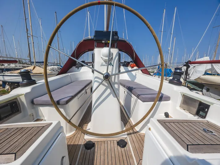  Yacht Photos Pics 2006 Hanse 370 sailboat cockpit with wooden wheel and seating, docked in a marina.