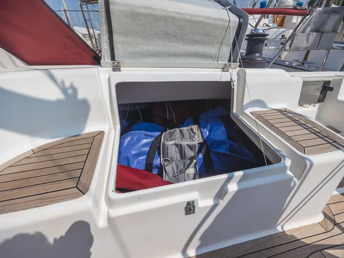  Yacht Photos Pics Storage compartment on a 2006 Hanse 370 sailboat, featuring wooden seating and colorful bags.