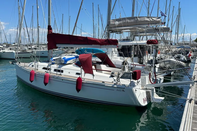  Yacht Photos Pics 2006 Hanse 370 sailboat docked in marina with red sail covers and fenders.