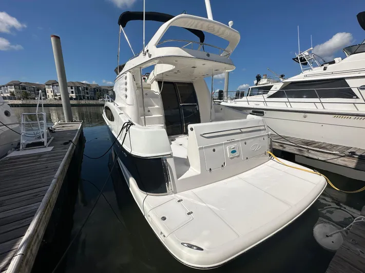Barbie Hunter Yacht Photos Pics 2007 Regal 4080 Flybridge Sedan docked at marina under clear blue sky.