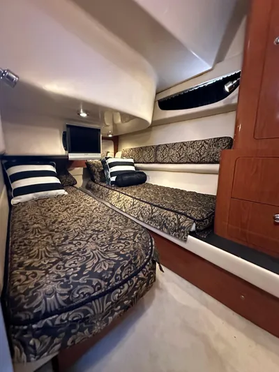 Barbie Hunter Yacht Photos Pics Luxurious cabin interior of 2007 Regal 4080 Flybridge Sedan with elegant bedding and wood accents.