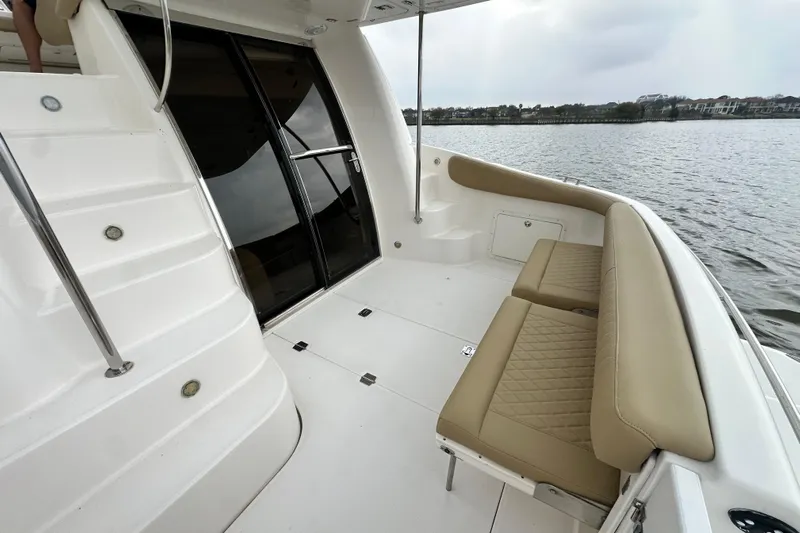 Barbie Hunter Yacht Photos Pics Regal 4080 Flybridge Sedan 2007, spacious deck with seating area by the water.