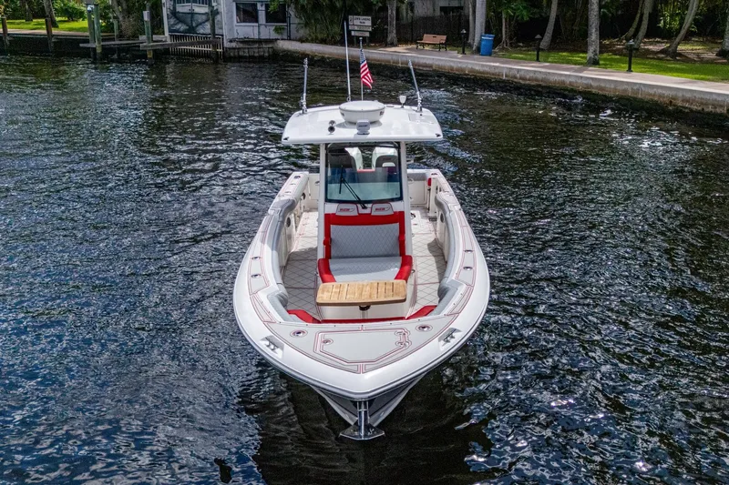 Dare To Dream's Sidechick Yacht Photos Pics 2018 Boston Whaler 330 boat on water, featuring sleek design and comfortable seating.