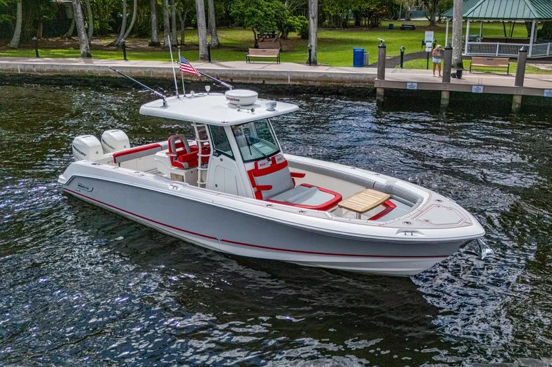 Dare To Dream's Sidechick Yacht Photos Pics 2018 Boston Whaler 330 boat on water, featuring sleek design and red accents.