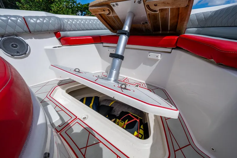Dare To Dream's Sidechick Yacht Photos Pics 2018 Boston Whaler 330 boat interior with red seating and open storage compartment.