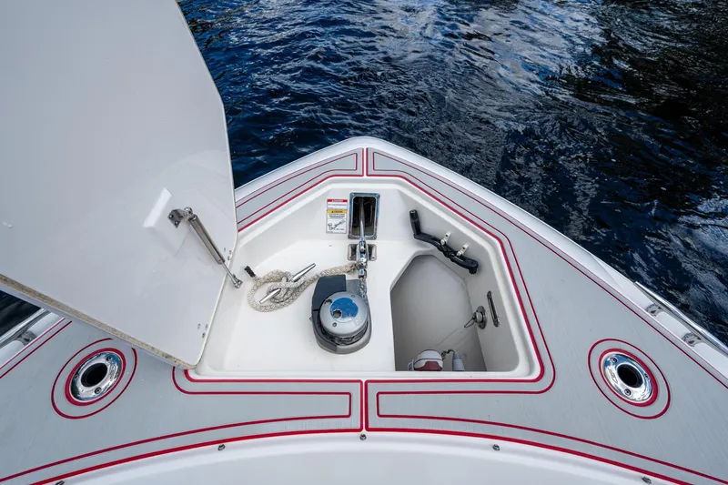 Dare To Dream's Sidechick Yacht Photos Pics 2018 Boston Whaler 330 boat anchor compartment with open hatch, on calm water.