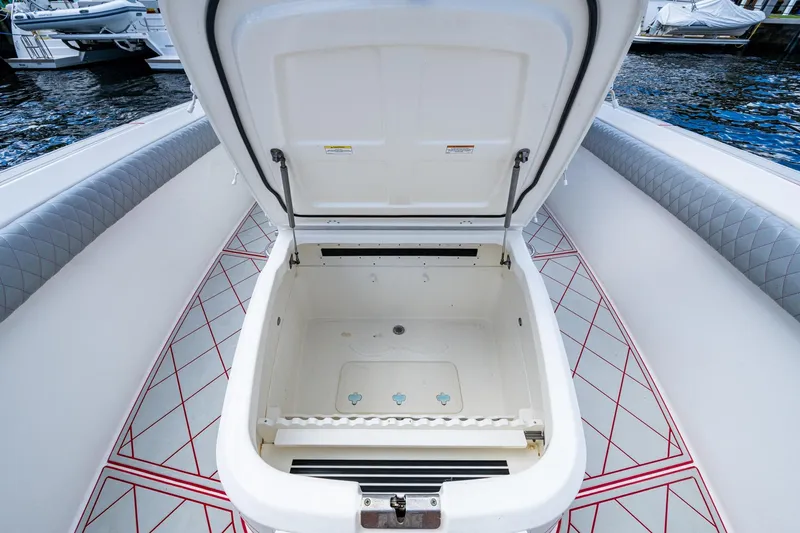 Dare To Dream's Sidechick Yacht Photos Pics Open storage compartment on 2018 Boston Whaler 330 boat, featuring quilted seating and patterned flooring.