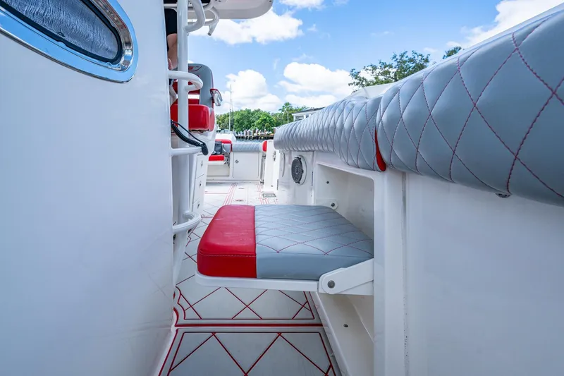 Dare To Dream's Sidechick Yacht Photos Pics 2018 Boston Whaler 330 interior with red and gray seating, showcasing modern design.