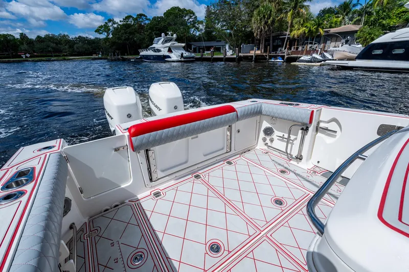 Dare To Dream's Sidechick Yacht Photos Pics 2018 Boston Whaler 330 boat interior with red accents, docked by waterfront homes.