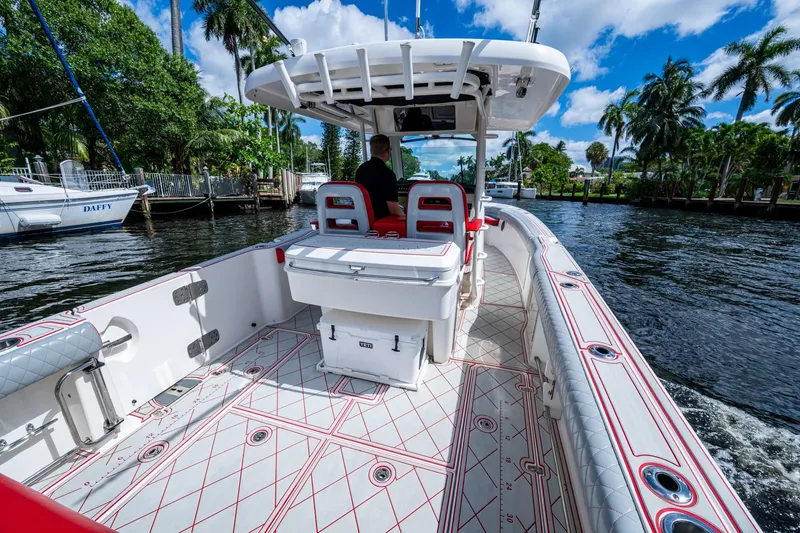 Dare To Dream's Sidechick Yacht Photos Pics 2018 Boston Whaler 330 boat cruising on a scenic waterway with palm trees.