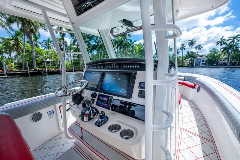 Dare To Dream's Sidechick Yacht Photos Pics 2018 Boston Whaler 330 boat cockpit with advanced navigation system and scenic waterfront view.
