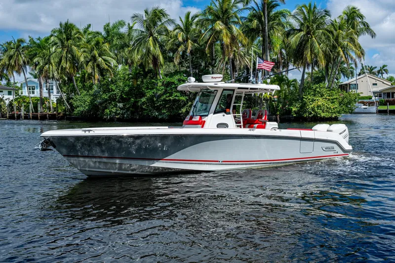 Dare To Dream's Sidechick Yacht Photos Pics 2018 Boston Whaler 330 boat cruising on a tropical waterway with palm trees.