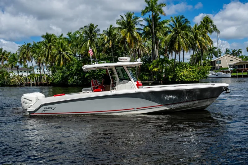 Dare To Dream's Sidechick Yacht Photos Pics 2018 Boston Whaler 330 boat cruising on a tropical waterway with palm trees.