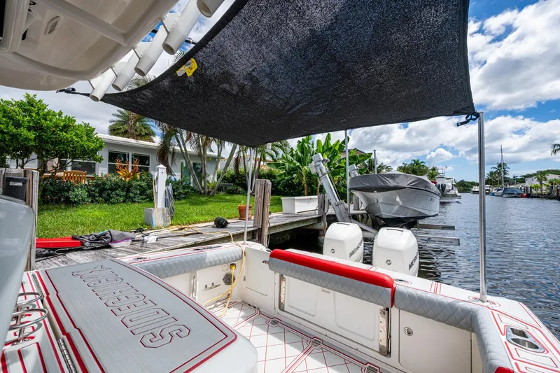 Dare To Dream's Sidechick Yacht Photos Pics 2018 Boston Whaler 330 boat docked, featuring shaded seating and twin engines.