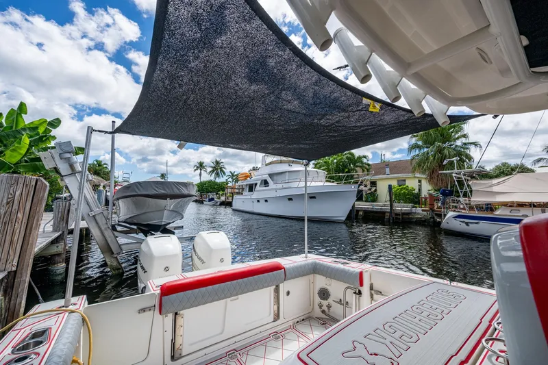 Dare To Dream's Sidechick Yacht Photos Pics 2018 Boston Whaler 330 boat docked, featuring dual engines and shaded seating area.