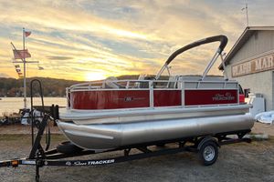 2026 Sun Tracker Bass Buggy 16 XL Select pontoon boat at sunset by a marina.