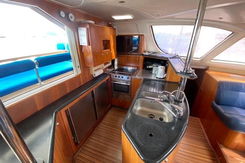  Yacht Photos Pics Catana 522 Ocean Class 2003 yacht interior kitchen with wood finish and modern appliances.