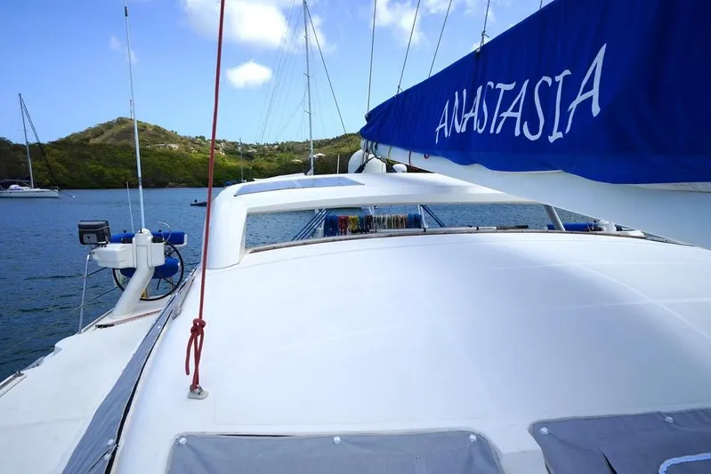 Yacht Photos Pics Catana 522 Ocean Class 2003 catamaran with blue sail cover, docked in scenic bay.