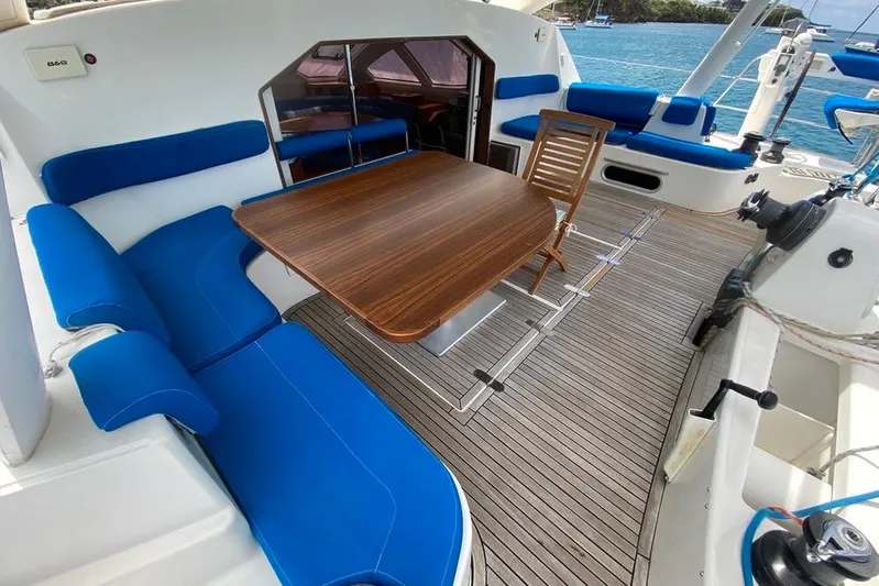  Yacht Photos Pics Luxurious Catana 522 Ocean Class 2003 yacht interior with blue seating and wooden table.