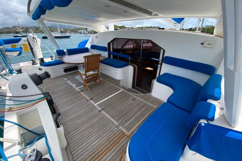  Yacht Photos Pics Spacious deck of 2003 Catana 522 Ocean Class catamaran with blue seating and wooden flooring.