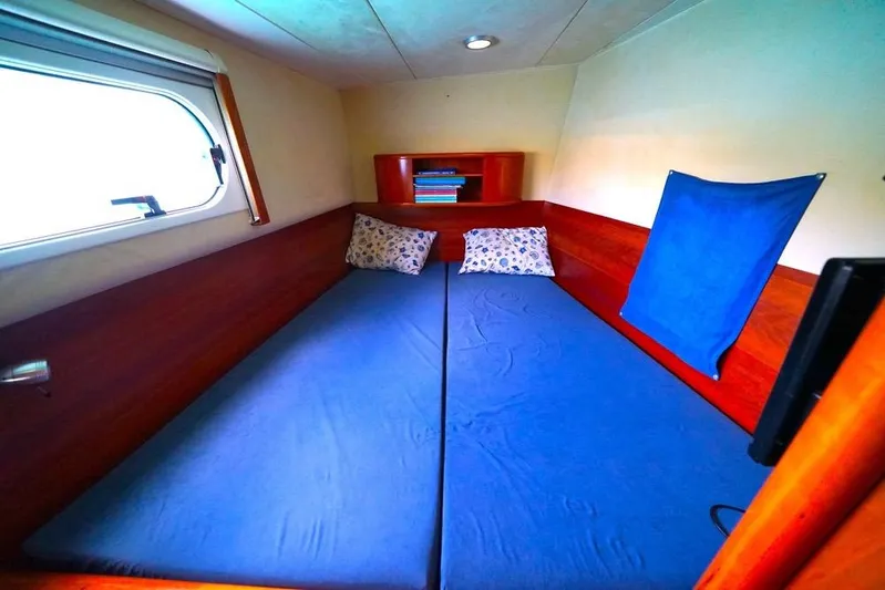  Yacht Photos Pics Cozy cabin interior of 2003 Catana 522 Ocean Class yacht with blue bedding.