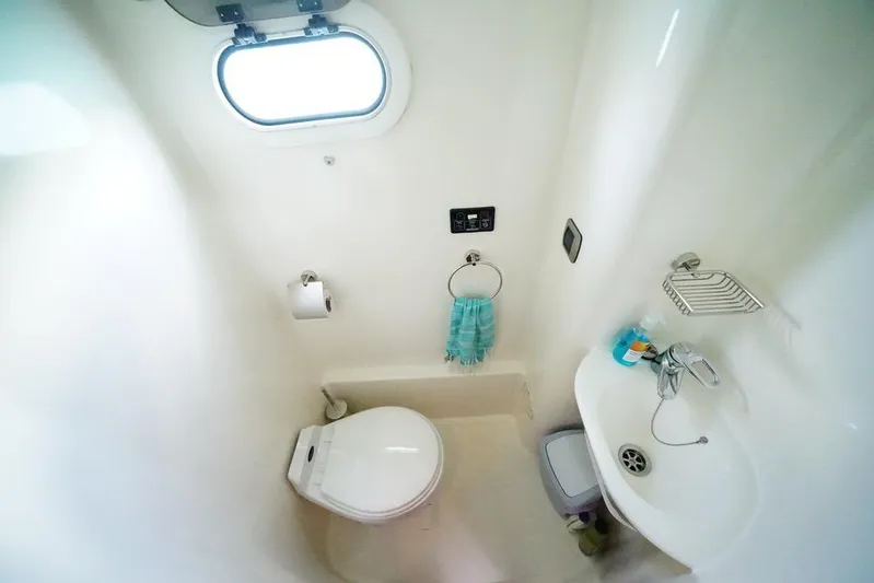  Yacht Photos Pics Compact bathroom in 2003 Catana 522 Ocean Class yacht, featuring toilet, sink, and porthole.