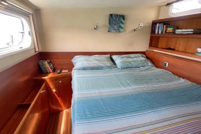  Yacht Photos Pics Cozy bedroom in 2003 Catana 522 Ocean Class yacht with striped bedding and bookshelves.