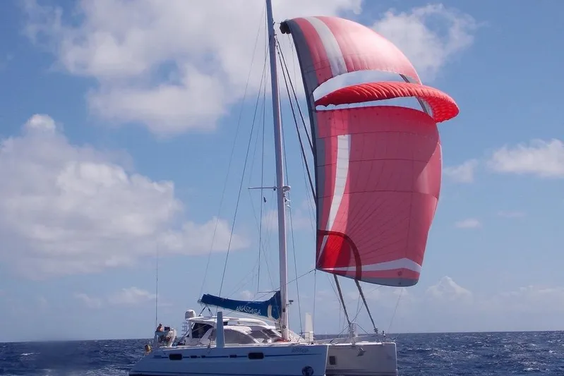  Yacht Photos Pics 2003 Catana 522 Ocean Class sailing with red spinnaker on open sea.