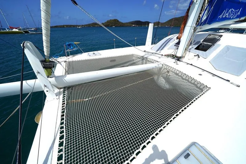  Yacht Photos Pics Catana 522 Ocean Class 2003 catamaran with netting, anchored in scenic bay.