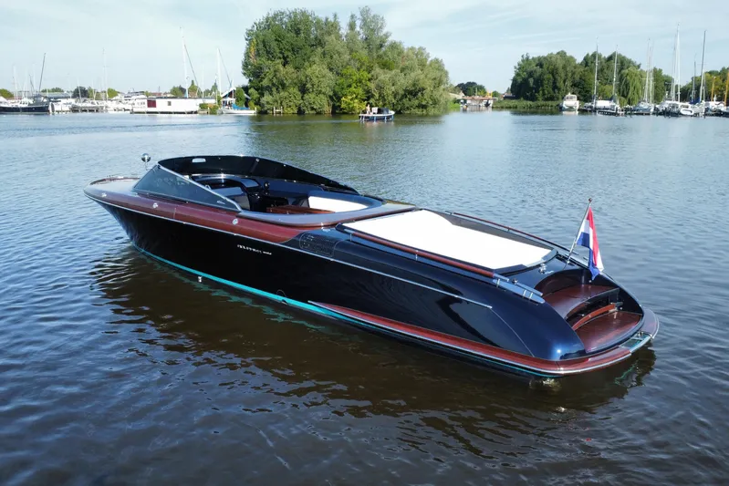  Yacht Photos Pics 2025 Riva Aquariva Special luxury boat on a serene lake with lush greenery.