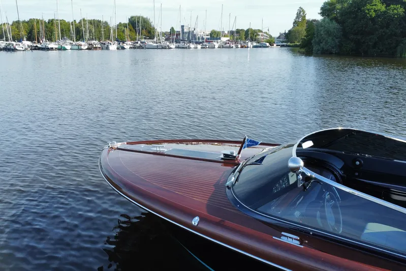  Yacht Photos Pics 2025 Riva Aquariva Special boat docked on calm waters near a marina.
