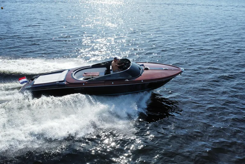  Yacht Photos Pics 2025 Riva Aquariva Special speedboat cruising on open water, creating a dynamic wake.