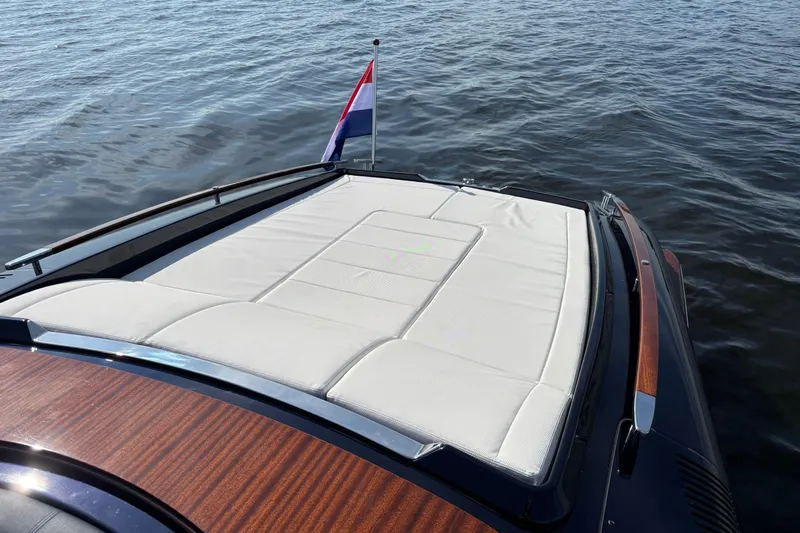  Yacht Photos Pics 2025 Riva Aquariva Special yacht with elegant deck and flag on calm water.