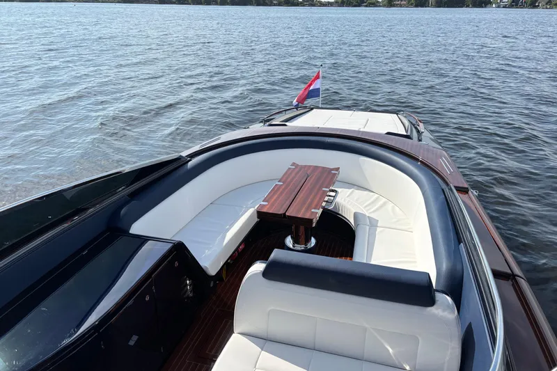  Yacht Photos Pics Luxurious 2025 Riva Aquariva Special yacht with elegant seating and wooden table on calm water.