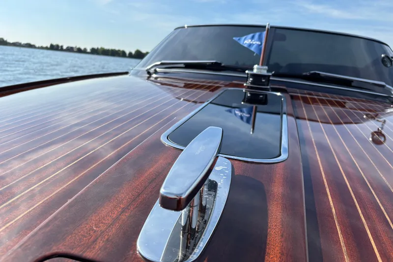  Yacht Photos Pics 2025 Riva Aquariva Special boat with polished wooden deck and chrome details on a sunny day.