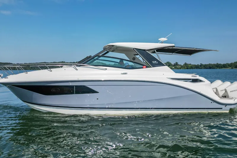 Sail Pending Yacht Photos Pics 2022 Sea Ray Sundancer 320 Outboard cruising on a serene lake under a clear blue sky.