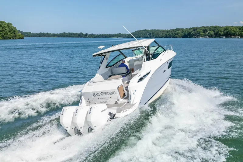 Sail Pending Yacht Photos Pics 2022 Sea Ray Sundancer 320 Outboard cruising on a serene lake with lush green shoreline.