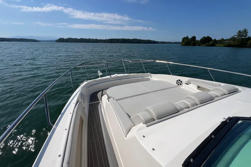 Sail Pending Yacht Photos Pics 2022 Sea Ray Sundancer 320 Outboard cruising on a serene lake under a clear blue sky.