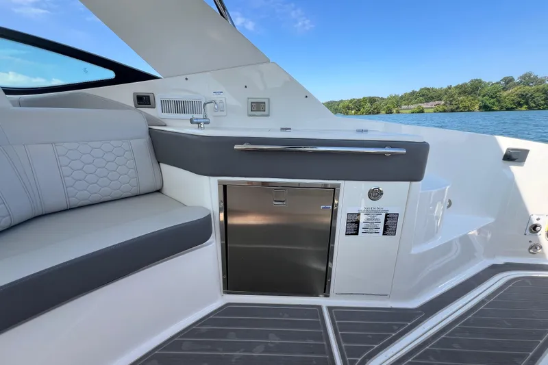 Sail Pending Yacht Photos Pics 2022 Sea Ray Sundancer 320 Outboard interior with seating, sink, and storage, on a sunny day.
