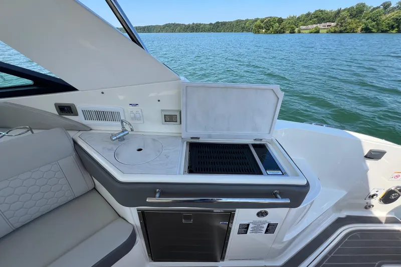 Sail Pending Yacht Photos Pics 2022 Sea Ray Sundancer 320 Outboard boat kitchen with grill and sink by the water.