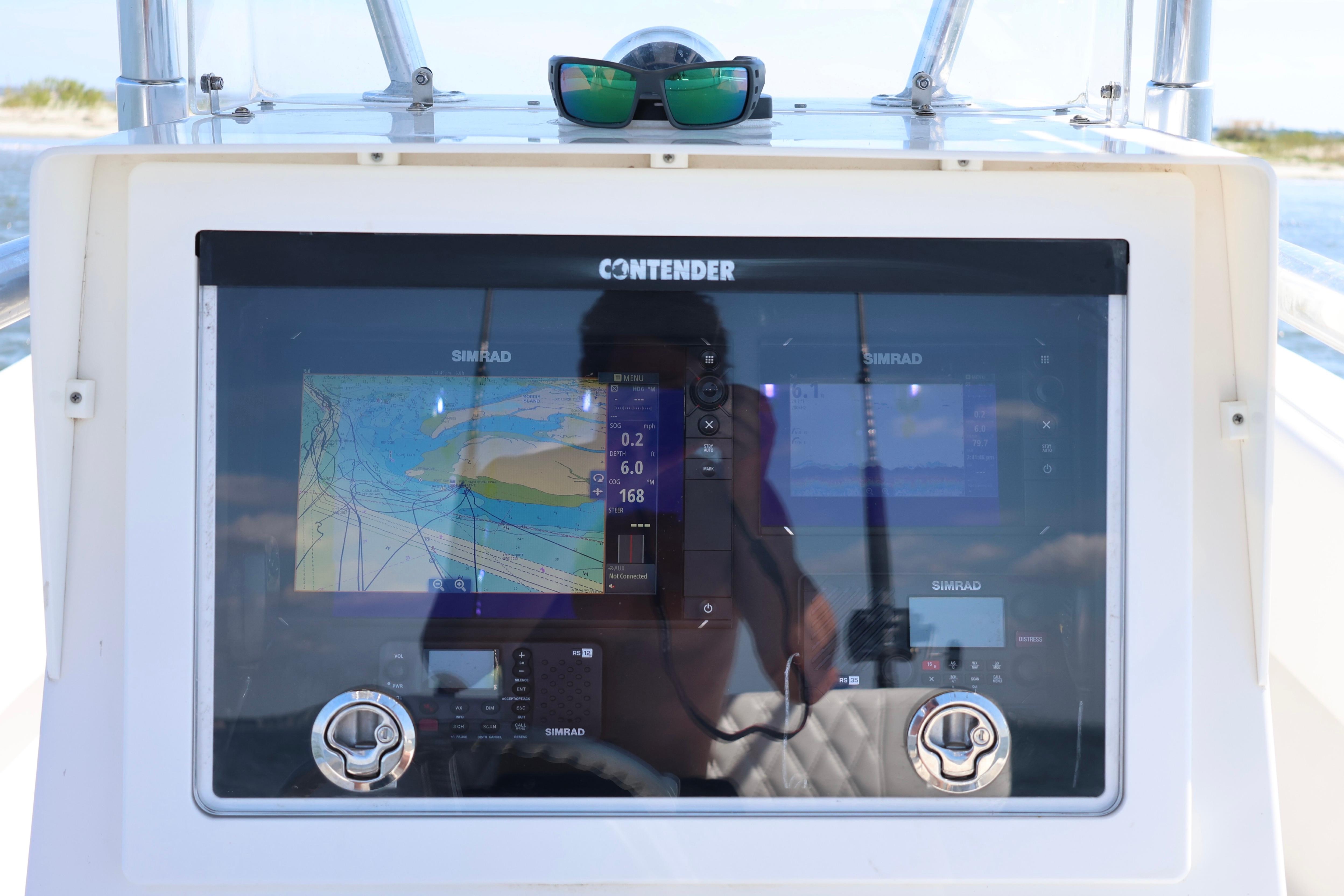 Control panel of a 2005 Contender 31 Cuddy boat with navigation screens.