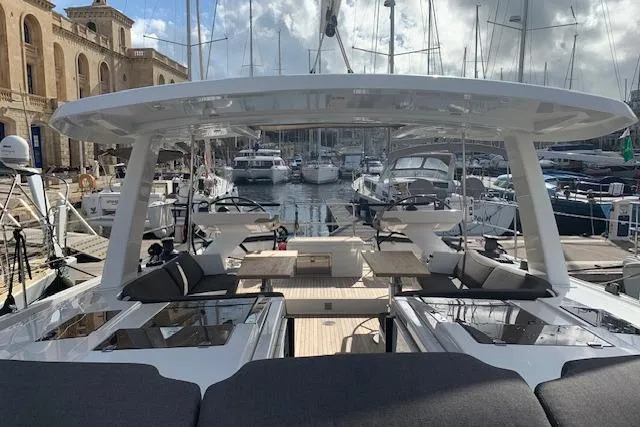  Yacht Photos Pics Luxurious 2017 Hanse 588 yacht docked at a marina, showcasing spacious deck and seating area.