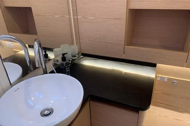  Yacht Photos Pics Modern bathroom interior on 2017 Hanse 588 yacht, featuring sleek sink and wooden cabinetry.
