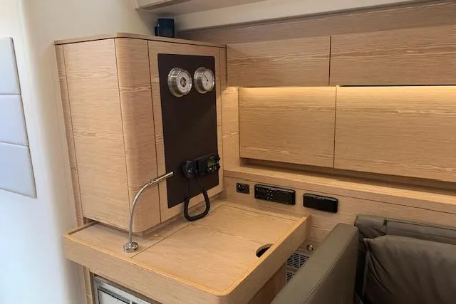  Yacht Photos Pics Interior of 2017 Hanse 588 yacht with modern wooden cabinetry and control panel.