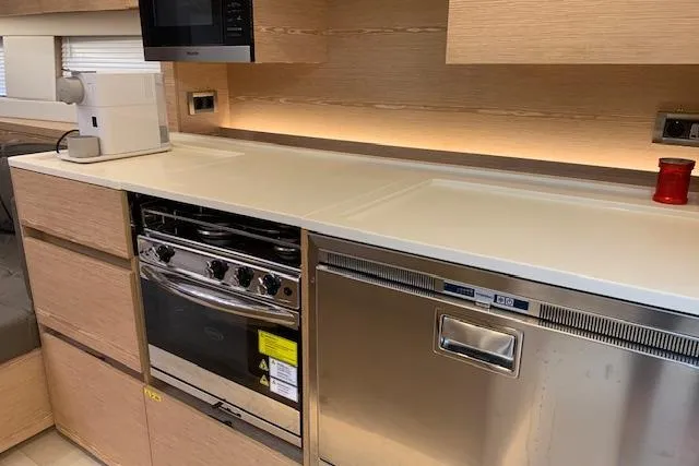  Yacht Photos Pics Modern kitchen interior of 2017 Hanse 588 yacht with sleek appliances and light wood cabinetry.