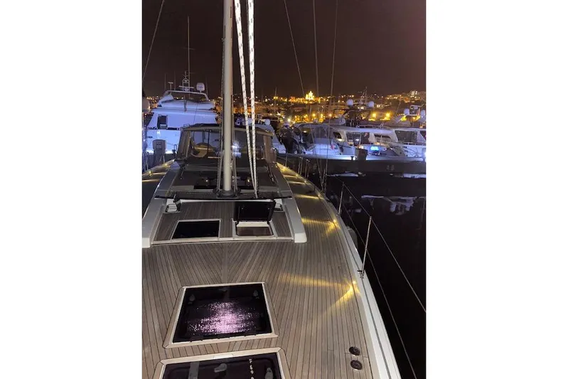  Yacht Photos Pics 2017 Hanse 588 yacht docked at night, illuminated with city lights in the background.