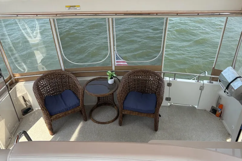  Yacht Photos Pics 2003 Carver 396 Motor Yacht deck with wicker chairs, table, and ocean view.