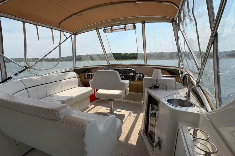  Yacht Photos Pics Interior of 2003 Carver 396 Motor Yacht with seating, helm, and kitchenette on a sunny day.